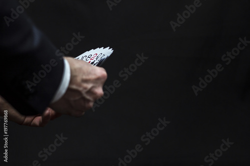 Playing cards in hands on a dark background