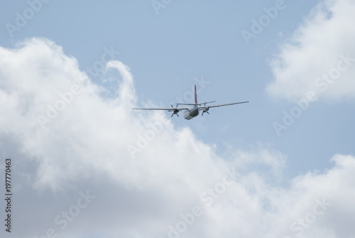 two-engined propeller airplane flying away