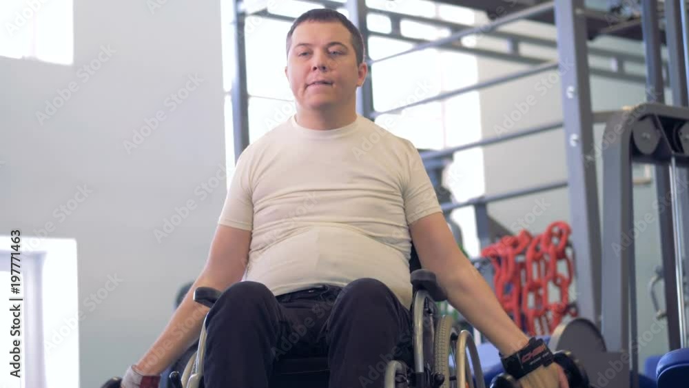 Workout process of a male invalid during which he is working with dumb-bells Workout process of a male invalid during which he is working with dumb-bells