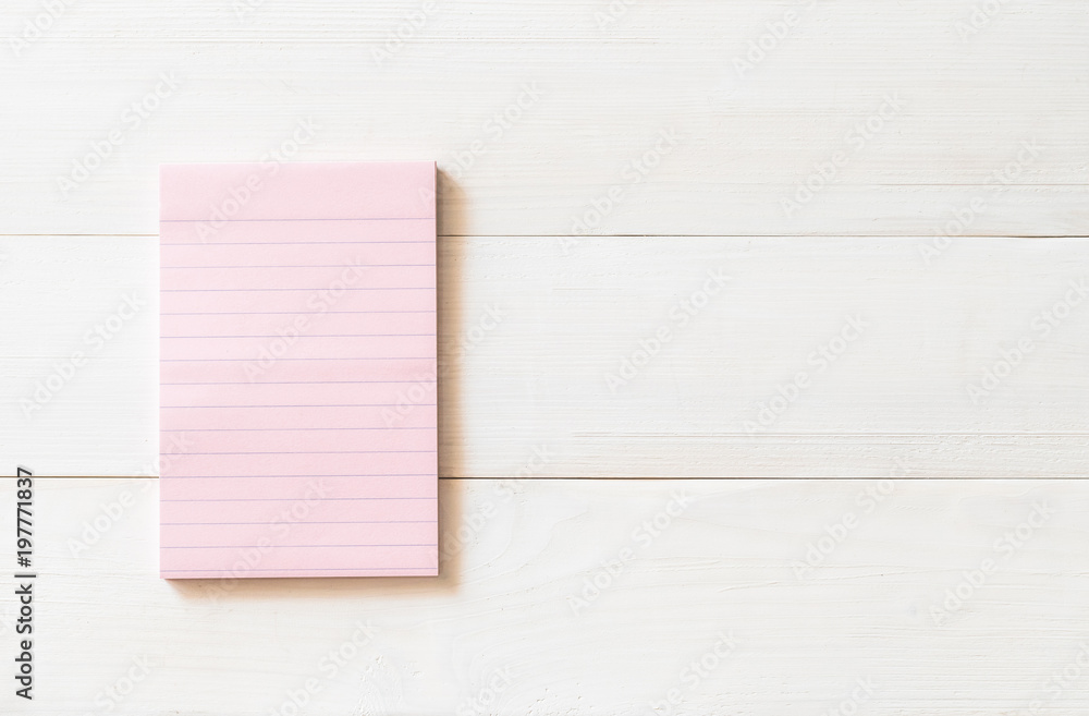 Naklejka premium One blank pastel sweet pink color reminder paper pad with horizontal line stripes on white pine wood