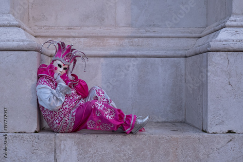 Woman dressed up as jester in pink costume at the Venice Carnival (Carnivale di Venezia)