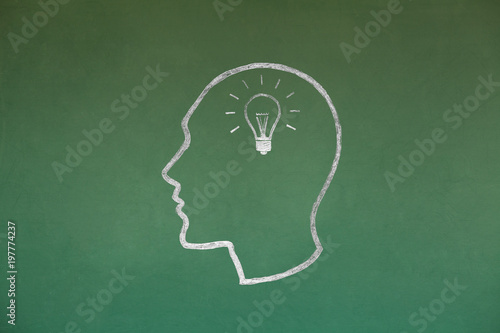 Idea Light Bulb Concept Drawing on Blackboard Texture