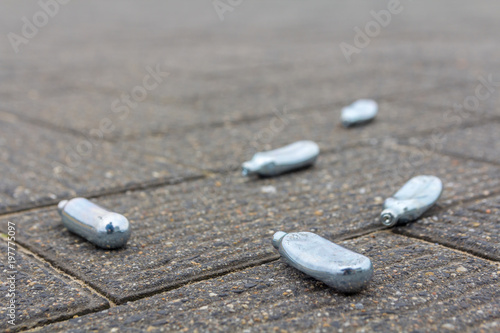 empty nitrous oxide bulbs lying scattered on the street, also known as laughing gas or hippie crack recreational drug, lying scattered on the street photo