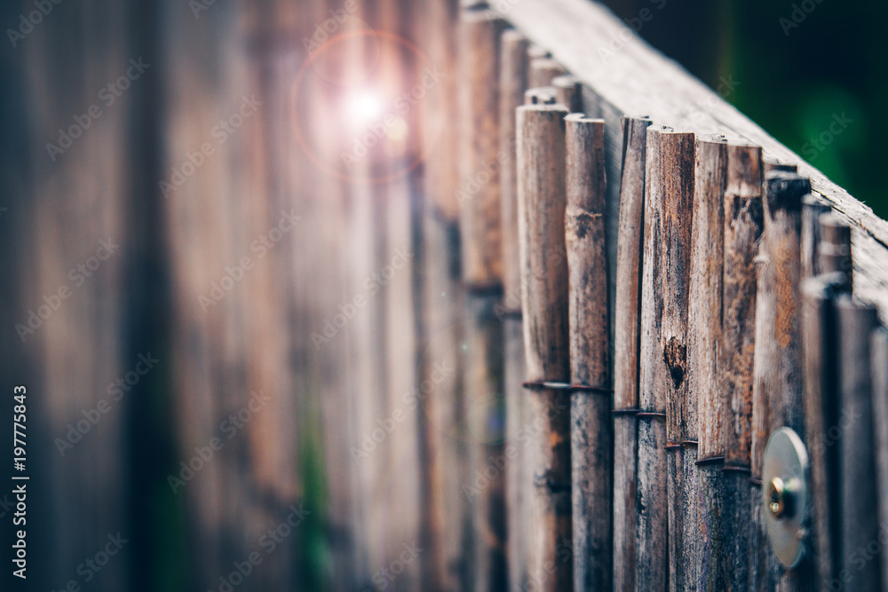 Textured fence made of thin wooden sticks aged and weathered. Natural background of wooden rails in a vertical row. Textured fence made of thin wooden sticks aged and weathered. Natural background of wooden rails in a vertical row.