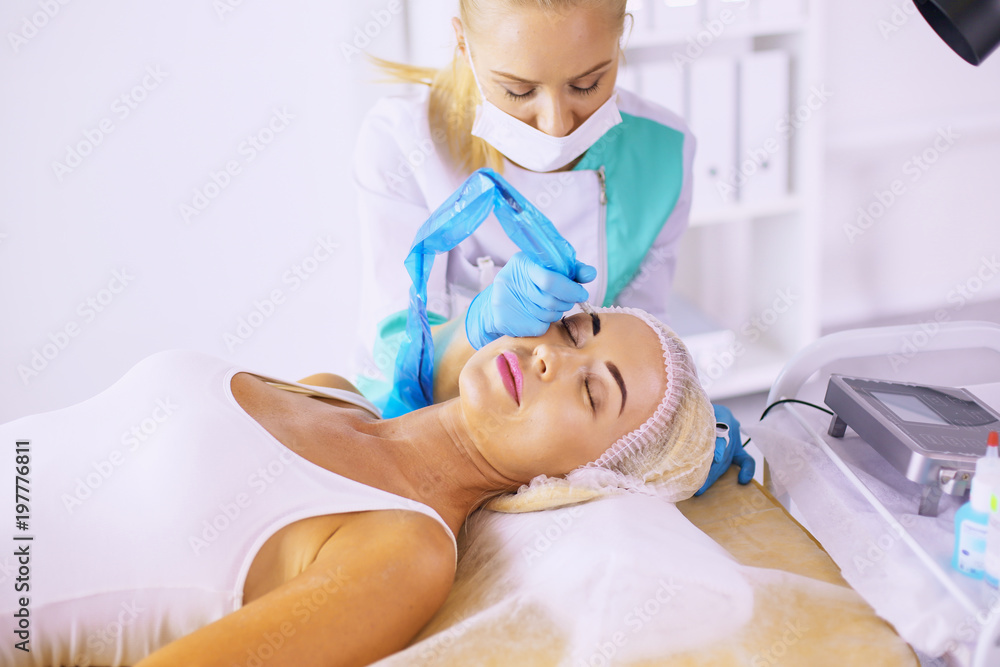Permanent Makeup For Eyebrows. Beautiful Woman With Thick Brows In Beauty Salon. Beautician Doing Eyebrow Tattooing For Female Face. Beauty Procedure Permanent Makeup For Eyebrows. Beautiful Woman With Thick Brows In Beauty Salon. Beautician Doing Eyebrow Tattooing For Female Face. Beauty Procedure
