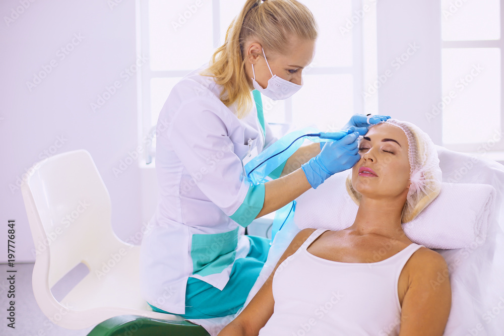 Permanent Makeup For Eyebrows. Beautiful Woman With Thick Brows In Beauty Salon. Beautician Doing Eyebrow Tattooing For Female Face. Beauty Procedure Permanent Makeup For Eyebrows. Beautiful Woman With Thick Brows In Beauty Salon. Beautician Doing Eyebrow Tattooing For Female Face. Beauty Procedure