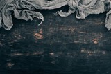 Old linen cloth on a black wooden background. Top view. Copy space for your text.