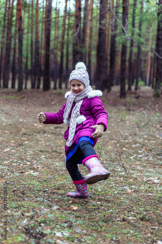 Cute little girl in pine forest in autumn time Cute little girl in pine forest in autumn time