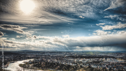 beautiful city view with blue sky, sun and rain clouds