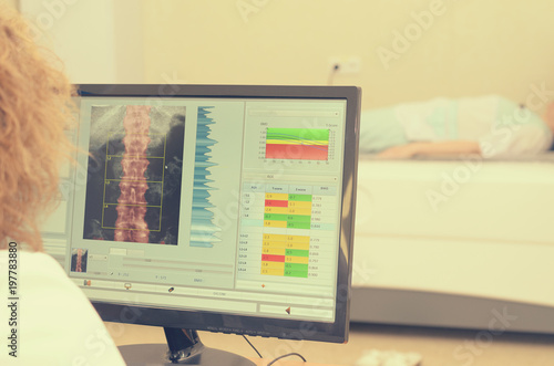 A woman x-ray examines the results of densitometry.