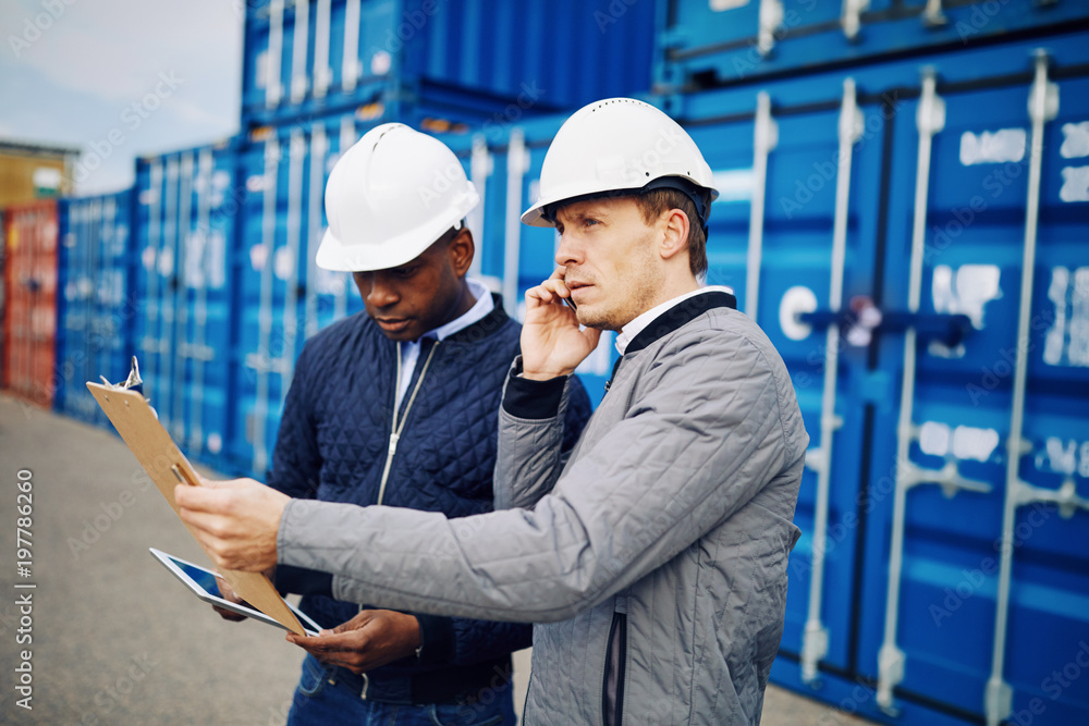 Engineers working in a large commercial freight shipping yard Engineers working in a large commercial freight shipping yard