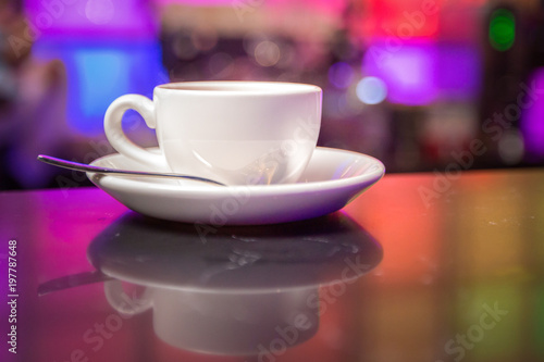 White teapot and tea cup on color lights background 