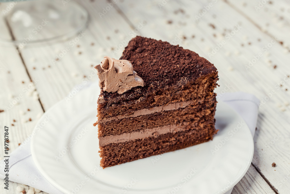 dark chocolate vegan cake with candies and cream on wooden background dark chocolate vegan cake with candies and cream on wooden background