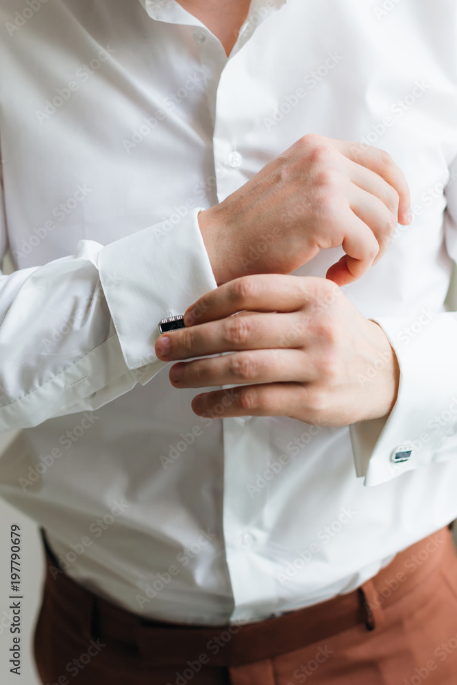 close-up of the groom who wears cufflinks in white shirt