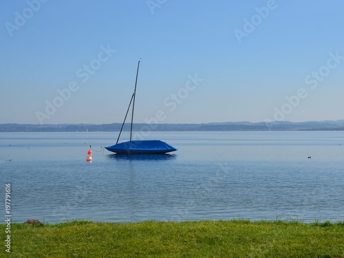 Boot im Chiemsee vor der Fraueninsel mit Abdeckplane