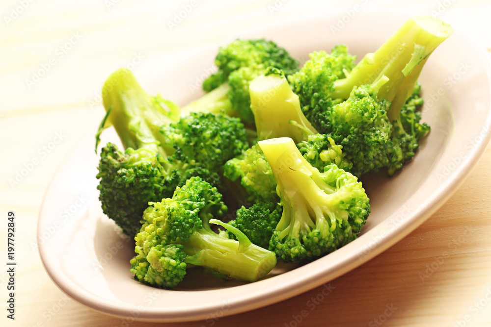 Green broccoli cabbage in plate on a wood background Green broccoli cabbage in plate on a wood background