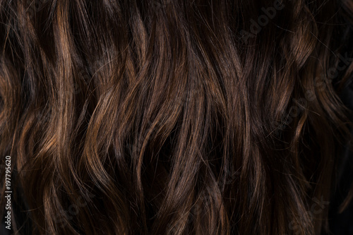Beautiful curvy dark brown hair with chocolate highlights. I photographed in the beauty salon during the work of the stylist. Stunning texture and wallpaper hair. Hair Background
