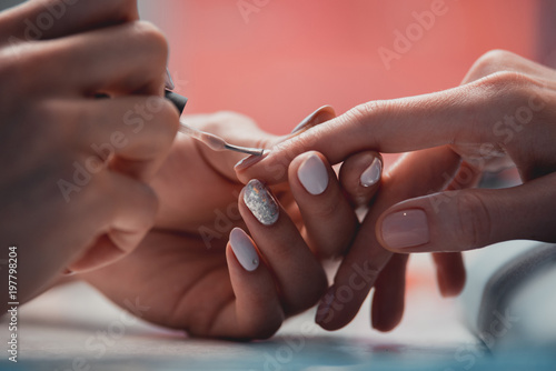 Close up female hands painting nails while locating on table photo
