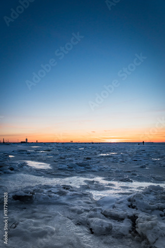 Frozen ocean at sunset - Baltic sea sunset with frozen sea and snow taken at beach in Tallinn  Estonia