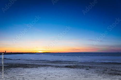 Frozen ocean at sunset - Baltic sea sunset with frozen sea and snow taken at beach in Tallinn  Estonia