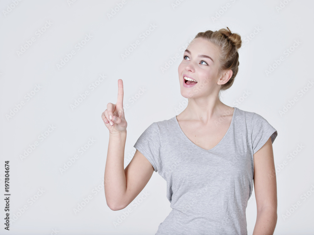 Smiling pretty woman pointing finger up Smiling pretty woman pointing finger up