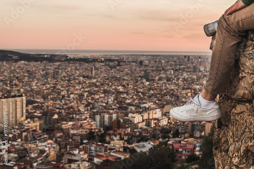Man on the top of a mountain watching the city of Barcelona, Spain.