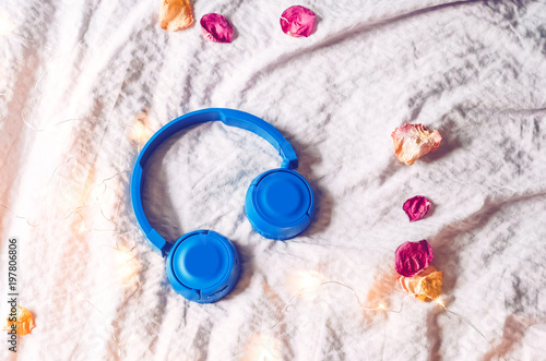 rose petals and a glowing garland. The headphones are blue.