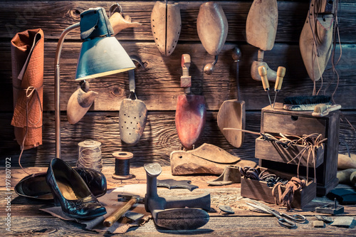 Shoemaker workplace with shoes, tools and laces