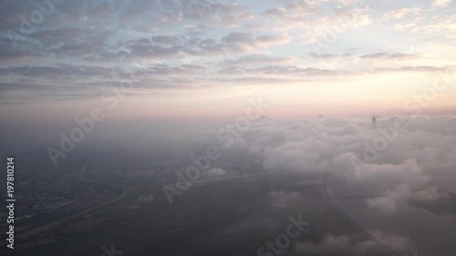 New York City aerial view approaching Manhattan from Jersey City while thick fog and low level clouds roll through the Financial District at sunrise.