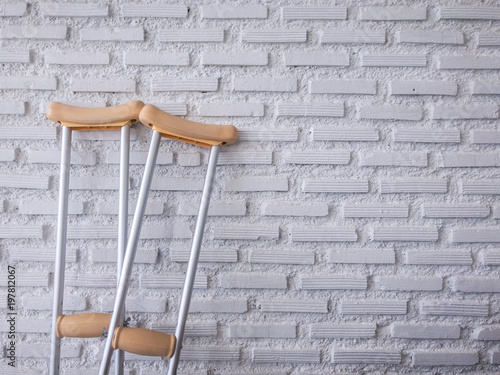 crutch on the white brick wall