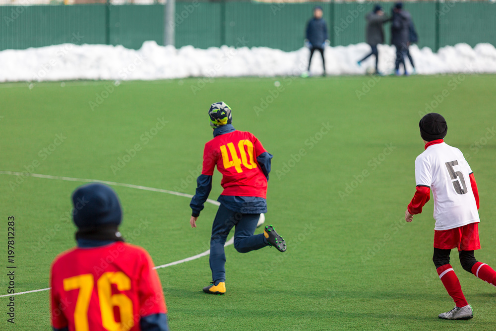 Obraz premium young boys play football, show dribbling, make passes to win on the winter field