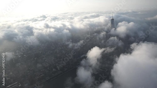 New York City aerial view of Lower Manhattan's Financial District, from above the Hudson River, covered in fog and low level clouds fom above the Hudson River.