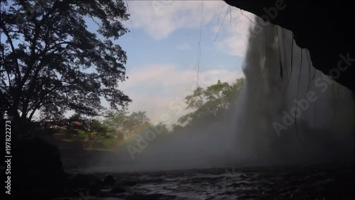 Landscape with waterfall, water pool and trees captured from behind low angle.