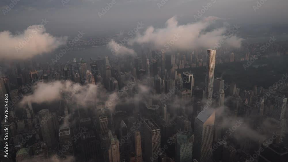 New York City aerial view flying over Midtown Manhattan skyscrapers and the Upper East Side under low level clouds at sunrise. New York City aerial view flying over Midtown Manhattan skyscrapers and the Upper East Side under low level clouds at sunrise.