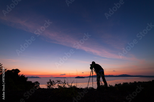 Professional photography man take a photo sunset or sunrise dramatic sky over the tropical sea in phuket thailand.