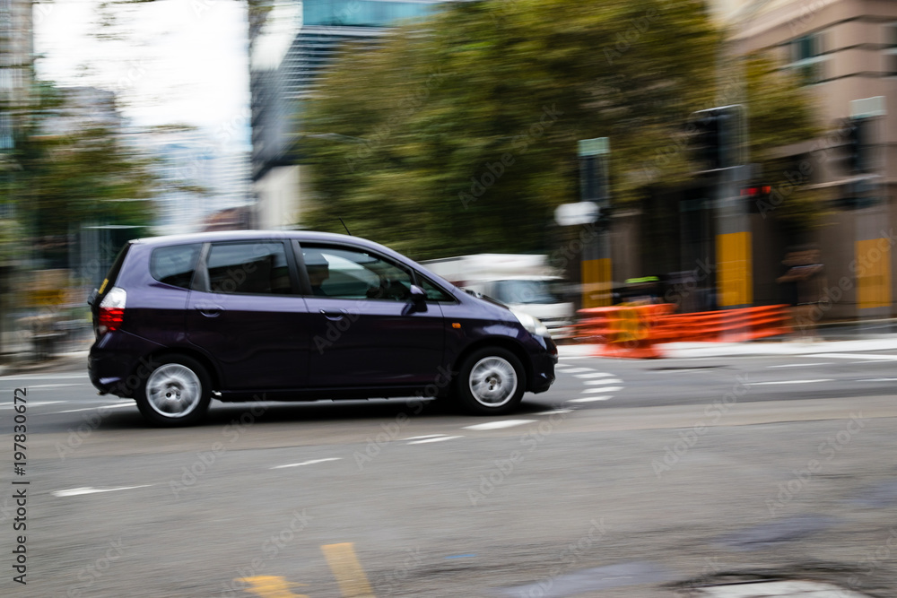 Car in motion on the road, Sydney, Australia. Car moving on the road, blurred buildings in background.
