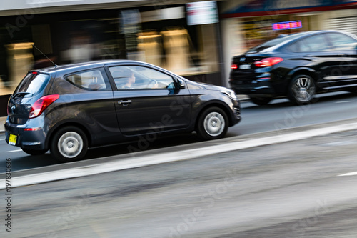 Cars in motion on the road, Sydney, Australia. Cars moving on the road, blurred buildings in background. © AVPHOTOSALES