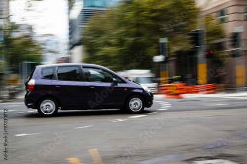 Car in motion on the road, Sydney, Australia. Car moving on the road, blurred buildings in background.
