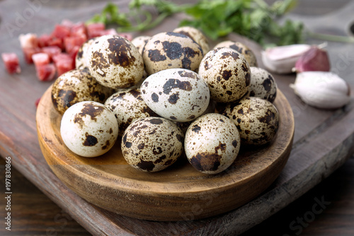 raw quail eggs on wood with other cooking ingredients