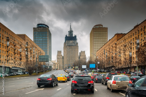 Fototapeta Naklejka Na Ścianę i Meble -  Traffic in a rainy spring Moscow. Dark stormy clouds. Contrasting sky. Dirty cars on the road