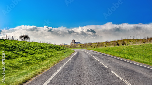 Empty straight road with lines towards a building far away