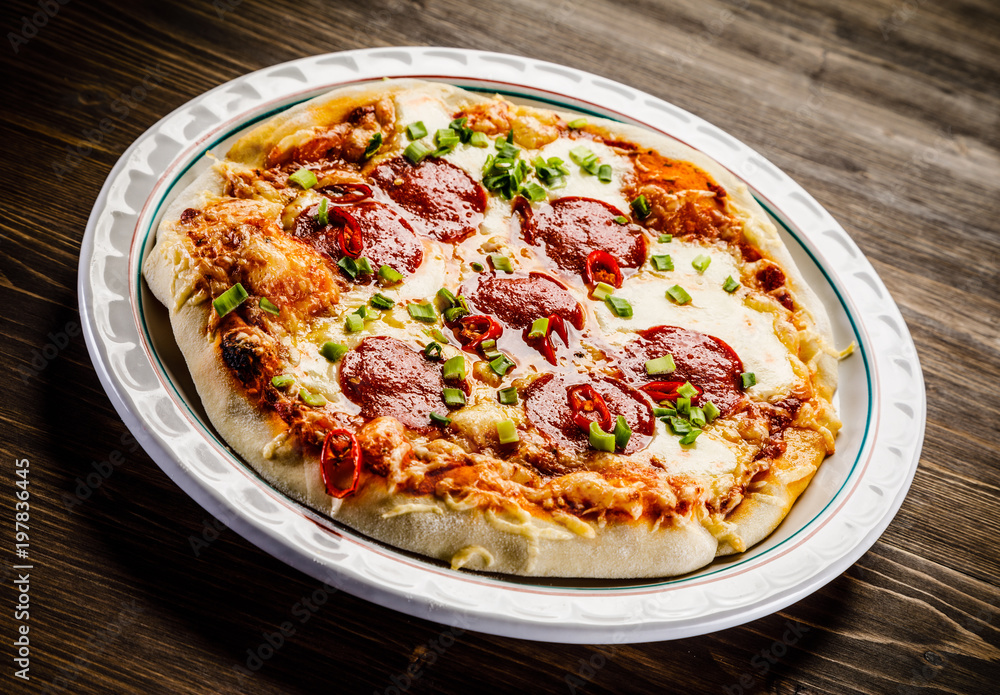 Pizza salami on wooden background