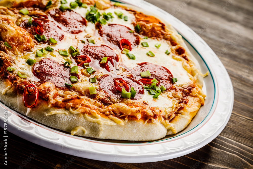 Pizza salami on wooden background Pizza salami on wooden background