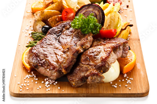 Roast steak with vegetables on cutting board