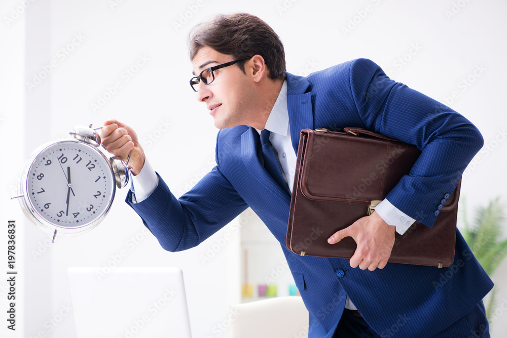 Businessman employee in urgency and deadline concept with alarm 