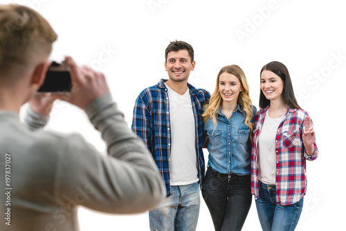 The four friends make a photo on the white background