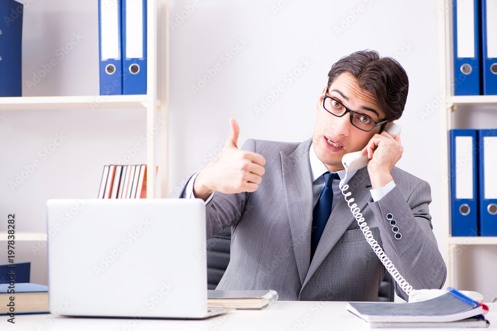 Businessman employee talking on the office phone Businessman employee talking on the office phone
