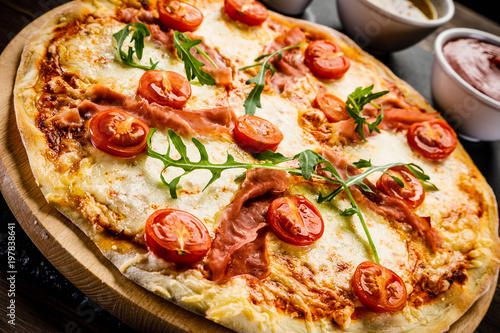 Pizza with ham and vegetables on wooden table