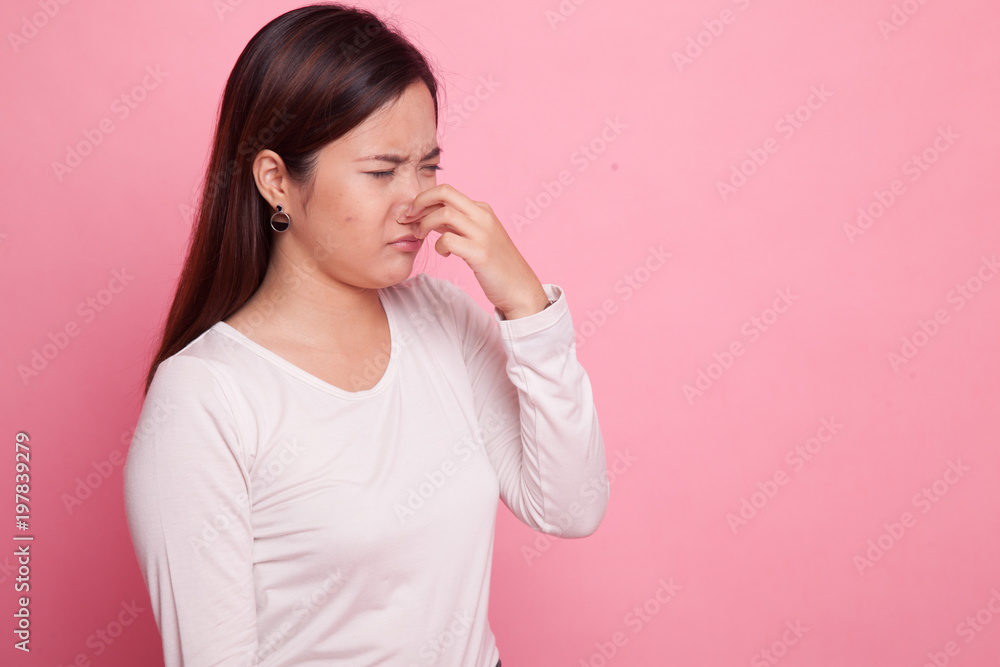 Young Asian woman holding her nose because of a bad smell. Young Asian woman holding her nose because of a bad smell.