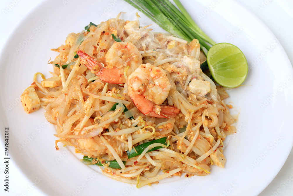 Thai style noodles, Pad Thai, stir-fried rice noodles with shrimp serve with vegetable in white plate on white background. The one of Thailand's national main dish. the popular food in Thailand.